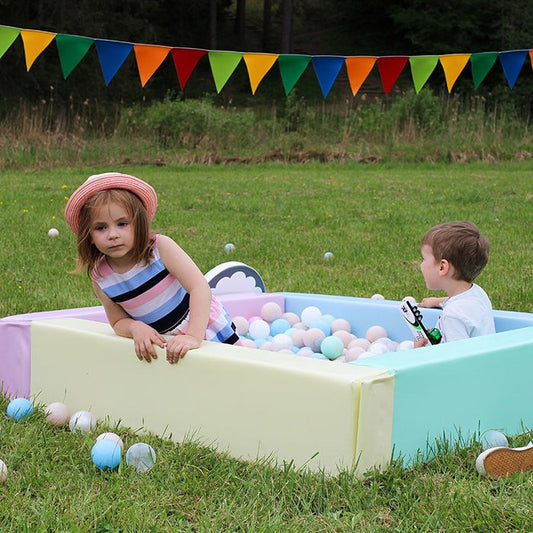 Kinderen spelen buiten in IGLU Foam Ballenbak Light Pastel gevuld met pastel ballen